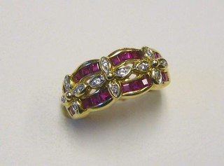 A lady's 18ct gold dress ring set 20 square cut rubies supported by floral set diamonds