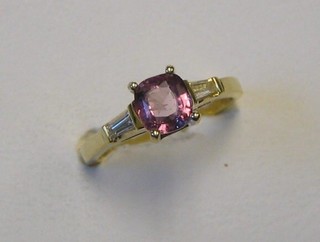 A lady's modern 18ct yellow gold dress ring set a circular pink sapphire, supported by 2 baguette cut diamonds
