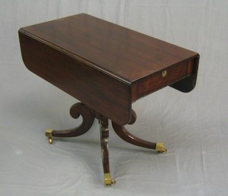 A 19th Century  mahogany pedestal Pembroke table  raised on a turned column and tripod supports ending in brass caps and castors 36"