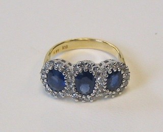 A lady's 18ct yellow gold dress ring set 3 oval cut sapphires surrounded by diamonds