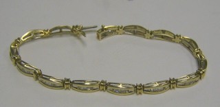 A lady's attractive 14ct gold bracelet, each link set baguette cut diamonds