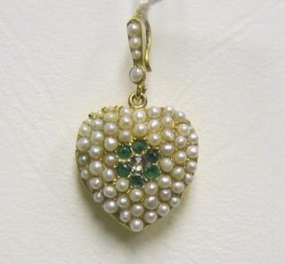 A lady's gold heart shaped pendant set numerous pearls and 6 emeralds with a diamond to the centre
