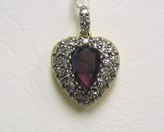 A lady's gold pendant set a heart shaped cut garnet supported by diamonds