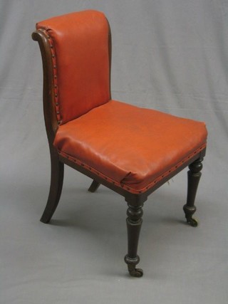 A William IV mahogany show frame standard chair upholstered red rexine, on turned supports ending in brass caps and castors