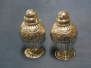 A pair of Victorian embossed silver pepperettes, London 1885, 2 ozs