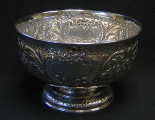 An Edwardian circular embossed silver bowl raised on a spreading foot, London 1900, 8"