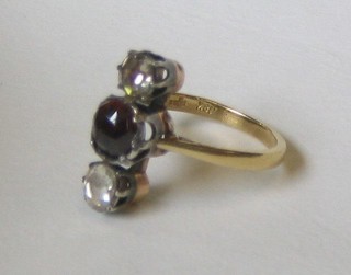 A lady's 18ct gold dress ring set a circular cut garnet supported by 2 diamonds