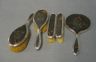 A silver and tortoiseshell backed 5 piece dressing table set comprising hand mirror, pair of hair brushes and pair of clothes brushes, Birmingham 1922