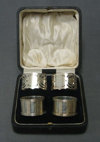 A pair of pierced silver napkin rings Sheffield 1947 and a pair of plain silver napkin rings Sheffield 1921, cased