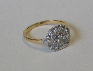 A lady's attractive Art Deco style dress ring set a circular diamond supported by 4 baguette cut diamonds and numerous small diamonds (approx. 0.61ct)