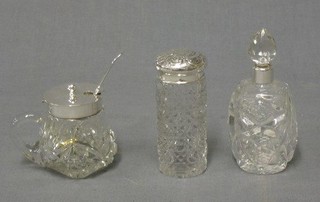 An Edwardian cylindrical cut glass dressing table jar with embossed silver lid 3" Birmingham 1902, a cut glass scent bottle with silver lid and a cut glass and silver plated mustard pot with spoon