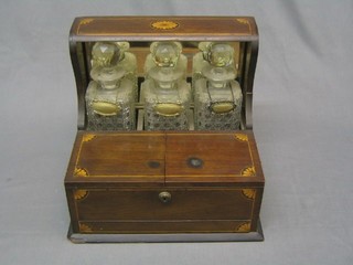 An Edwardian inlaid mahogany 3 bottle tantalus with 3 hobnail cut glass decanters (1 base chipped and all stoppers with chipped) with plated decanter labels