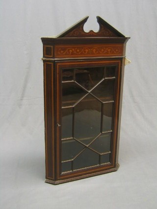 An Edwardian inlaid mahogany hanging corner cupboard, fitted adjustable shelves enclosed by an astragal glazed panelled door, 23"