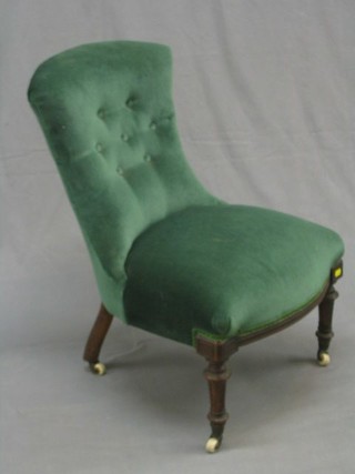 A Victorian mahogany framed nursing chair upholstered in green buttoned material, on turned and fluted supports
