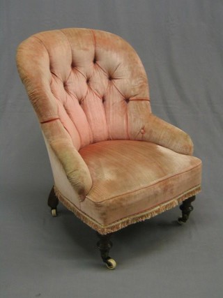 A Victorian mahogany framed tub back nursing chair upholstered in pink buttoned material, on turned supports