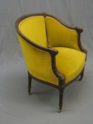 A Victorian carved walnut tub back library chair upholstered in mustard coloured material, raised on turned and reeded supports