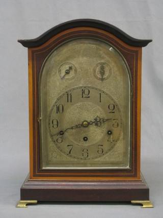 An Edwardian German 9 day striking bracket clock with silvered arched dial and Arabic numerals, strike/chime indicator and slow/fast indicators, contained in an arched inlaid mahogany case