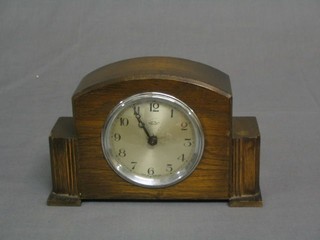 A 1930's electric clock with silvered dial in an oak case