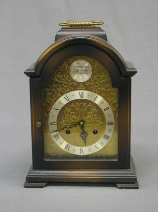 A  reproduction Queen Anne style striking bracket clock with arch shaped engraved brass dial with silver chapter ring contained in a mahogany case