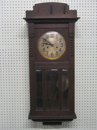 A 1930's striking wall clock with silvered dial and Arabic numerals contained in an oak case