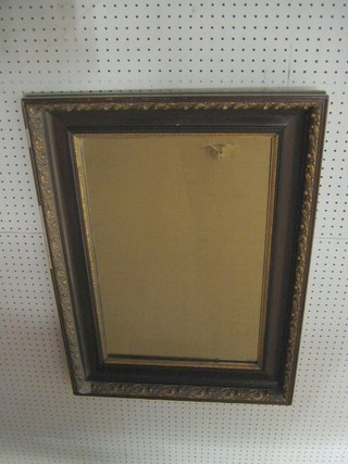 A 19th Century rectangular plate wall mirror contained in a walnut and gilt finished frame 30"