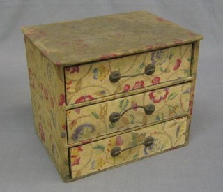 A fabric covered chest of 3 drawers, 2 compacts, a purse and a lady's evening bag