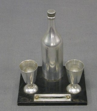 A 1920's aluminium and ebony finished table lighter in the form of a bottle of wine with 2 glasses 4"