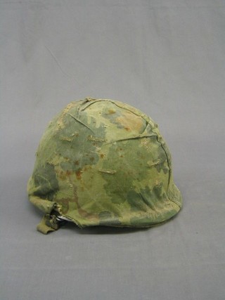An American steel helmet complete with liner and camouflage cover