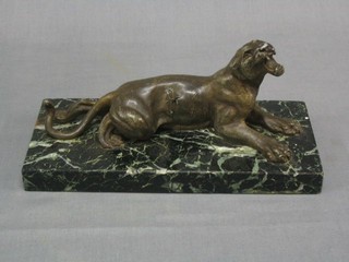 A spelter figure of a reclining big cat with spear in its side, raised on a marble base 10"