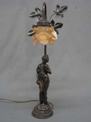 An Art Nouveau style bronzed table lamp with pink glass shade