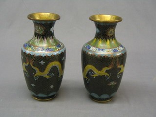A pair of cloisonne enamelled vases decorated dragons against a black ground 9"