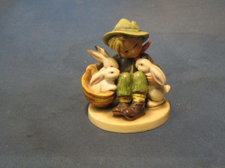 A Hummel figure of a seated boy with basket of rabbits and rabbit, base with crowned CW mark 4" (hat f)