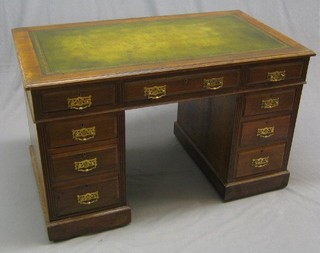 An Edwardian walnut kneehole pedestal desk with inset tooled leather writing surface, above 9 drawers 48"