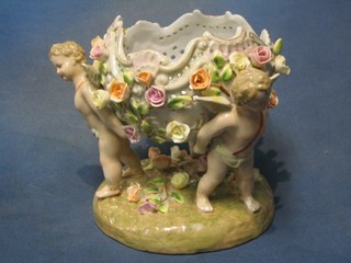 A Dresden style porcelain table centre piece supported by cherubs 7"