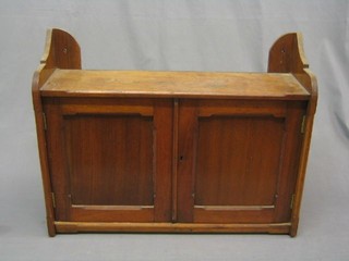 An Edwardian walnut hanging cabinet, fitted a shelf enclosed by panelled doors 24"