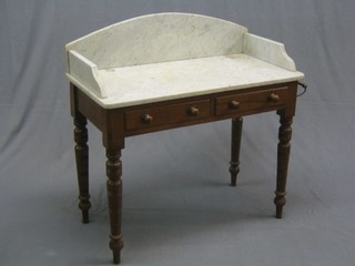 A Victorian mahogany wash stand with white veined marble and three-quarter gallery top, the base fitted 2 drawers and raised on ring turned supports 36"