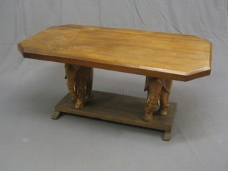 A lozenge shaped Eastern hardwood coffee table supported by 2 walking elephants 42"