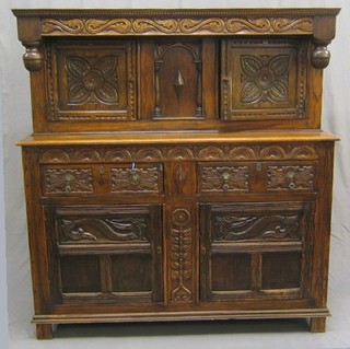 A 17th Century style carved oak court cupboard, the upper section fitted 2 cupboards, the base fitted 2 drawers above double cupboards, carved throughout 59"