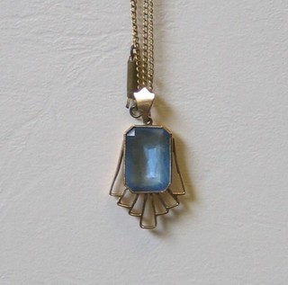 A lady's gold pendant set a rectangular cut aquamarine hung on a fine gold chain