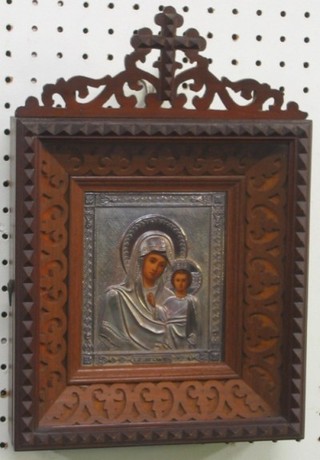 A handsome Russian silver Icon of "The Virgin Mary and Christ" contained in an embossed silver frame and with in a carved hardwood outer frame 5" x 4"