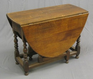 A 17th Century style carved oak oval drop flap gateleg dining table, fitted a frieze drawer raised on turned and block supports 40"