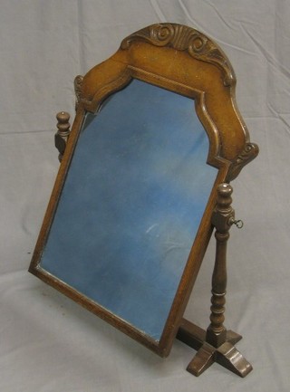 An 18th Century style arch shaped plate dressing table mirror contained in a walnut and oak swing frame