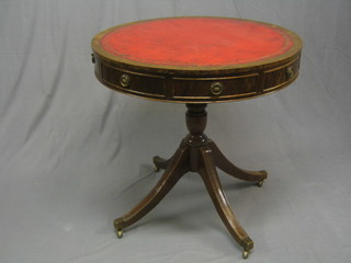 A Georgian style mahogany drum table with leather top, raised on bulbous turned and tripod supports ending in brass caps and castors 30"
