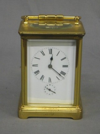 A French 19th Century 8 day alarm carriage clock with porcelain dial, Roman numerals and alarm indicator, contained in a gilt case