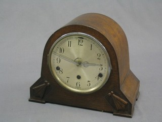 A 1930's chiming mantel clock with silvered dial and Arabic numerals contained in an arch shaped case