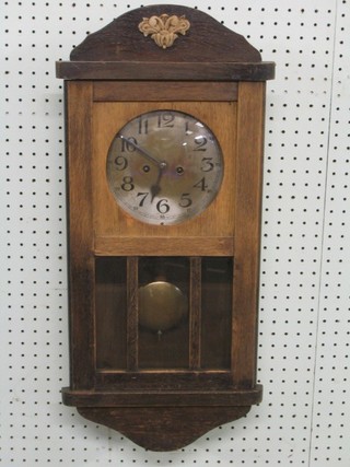 A 1930's 8 day striking wall clock with silvered dial and Arabic numerals contained in an oak case