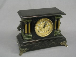 A Victorian American 8 day striking mantel clock contained in a wooden architectural style case