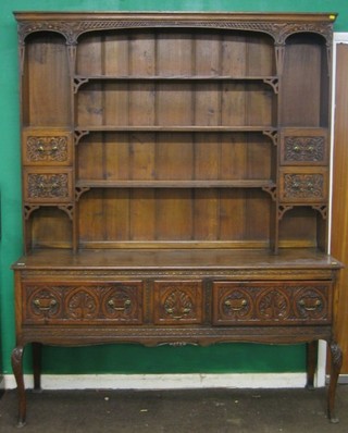A Victorian Art Nouveau carved oak dresser, the raised back with moulded cornice, fitted shelves and niches flanked by 4 short drawers, the base fitted 1 short drawer and 2 long drawers, raised on cabriole supports, carved throughout