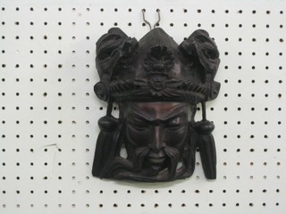 An Eastern carved hardwood wall mask