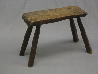 A well weathered oak bench, raised on outswept supports 25"